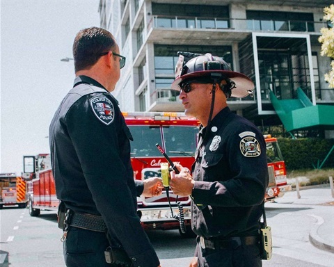 police officer and fire captain discuss in front of fire engine